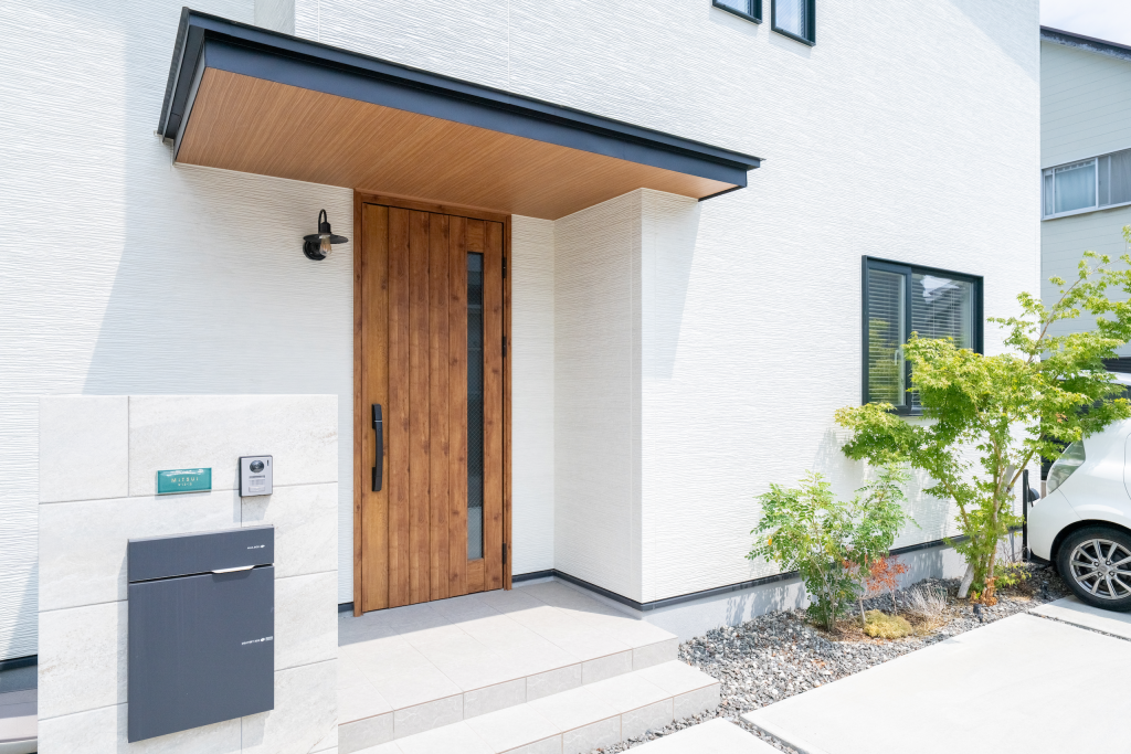 木製ドアとタイル外壁が調和するおしゃれな玄関アプローチ｜ナチュラルモダンな注文住宅｜Pal & Park