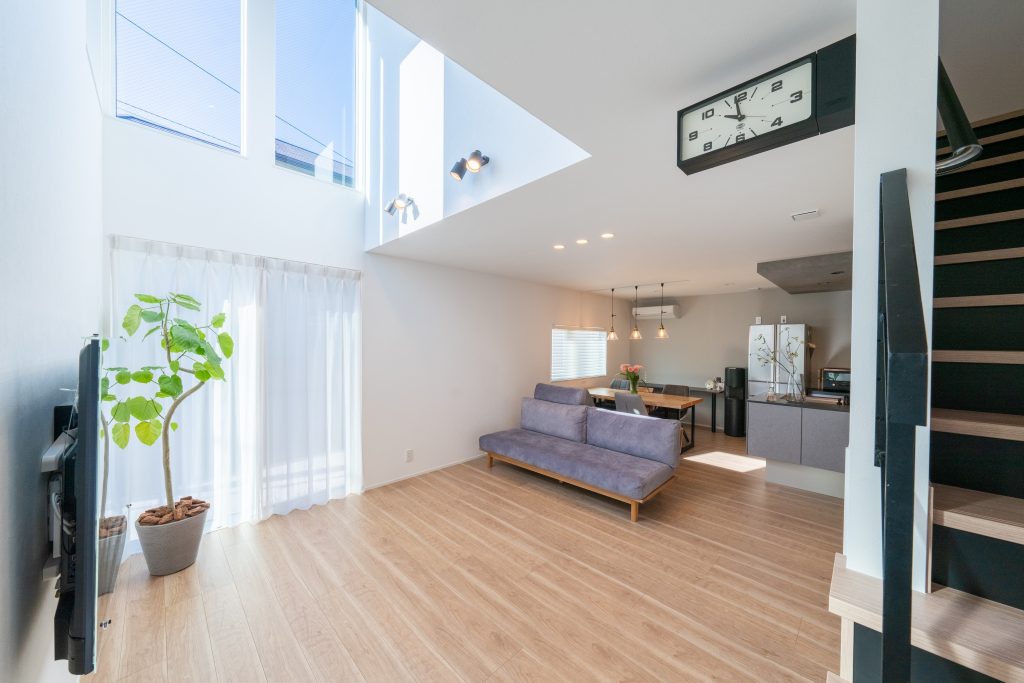 吹き抜けから光が差し込むリビング。ベビーマッサージ教室を開ける広々としたスペースを備えた住まい。