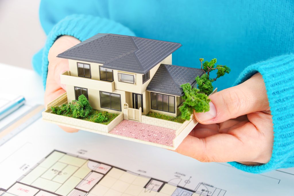 住宅模型を両手で包み込みながら、住まいの形や完成イメージを確認している様子