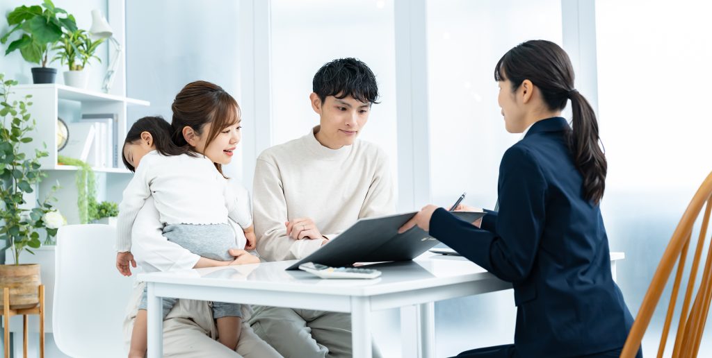 家族がテーブルを囲み、住まいについて担当者と打ち合わせをしている様子